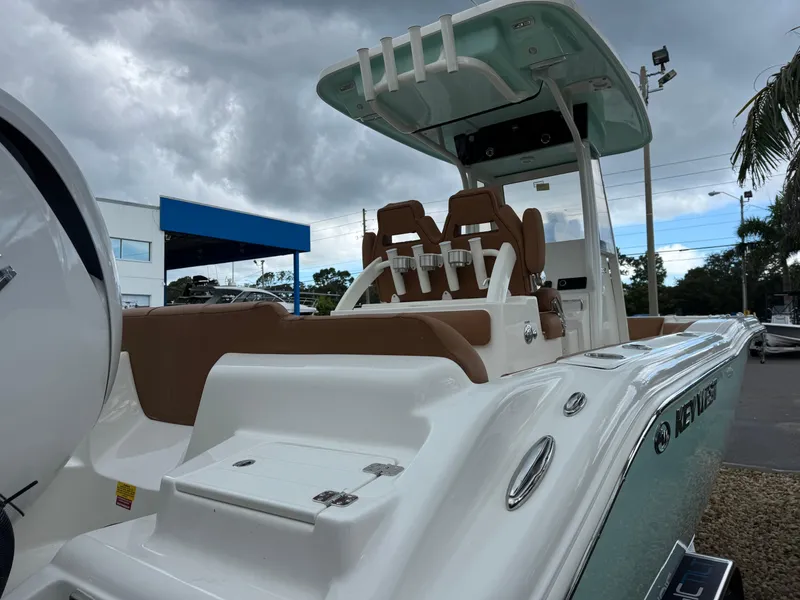 Slide: The Image of 2026 Key West 239 FSR boat with sleek design, brown seating, and modern features under cloudy skies. - 10