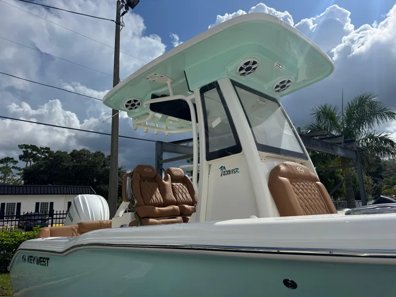 Slide: The Image of 2026 Key West 239 FSR boat with sleek design and luxurious seating under a cloudy sky. - 11