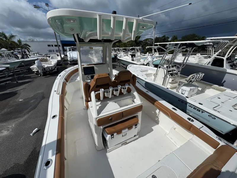 Slide: The Image of 2026 Key West 239 FSR boat with brown seating, docked among other boats under cloudy skies. - 13
