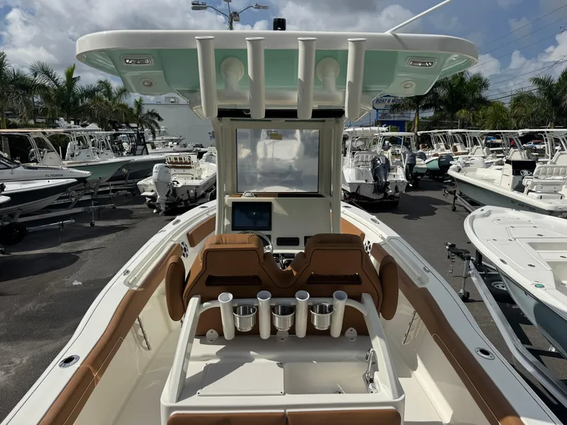 Slide: The Image of 2026 Key West 239 FSR boat interior with seating and cup holders, displayed at a dealership. - 16