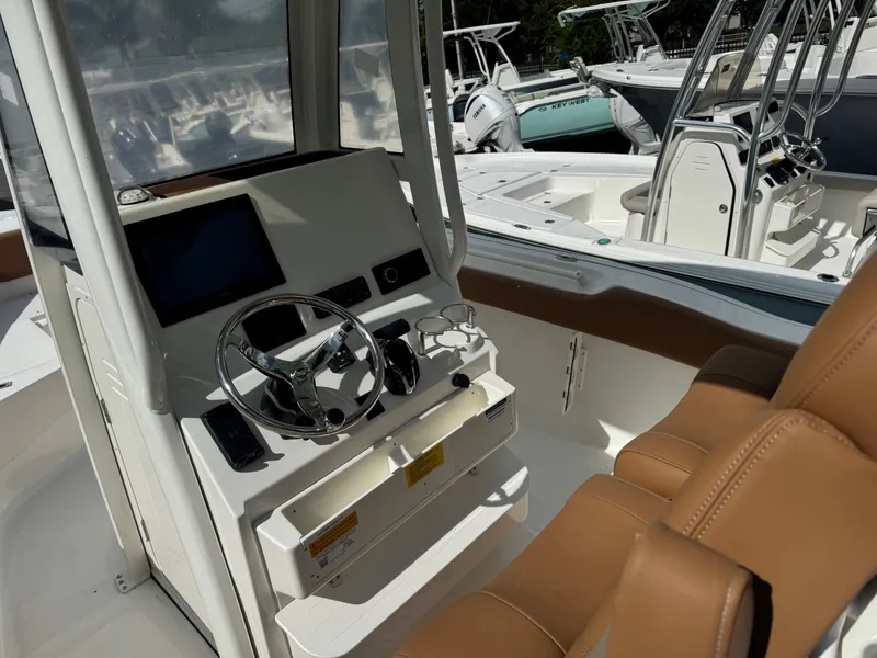 Slide: The Image of Interior of 2026 Key West 239 FSR boat with steering wheel and brown seats. - 18