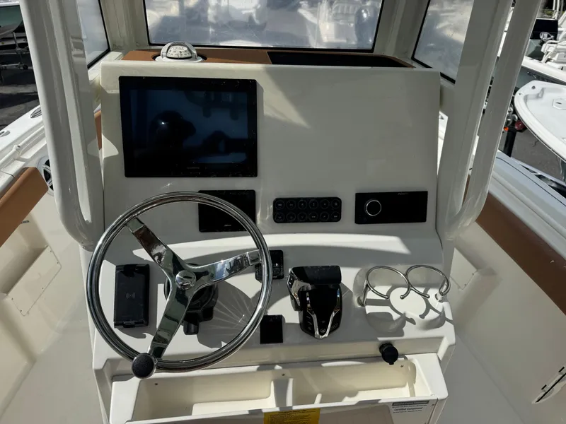 Slide: The Image of 2026 Key West 239 FSR boat dashboard with steering wheel, controls, and display screen. - 19