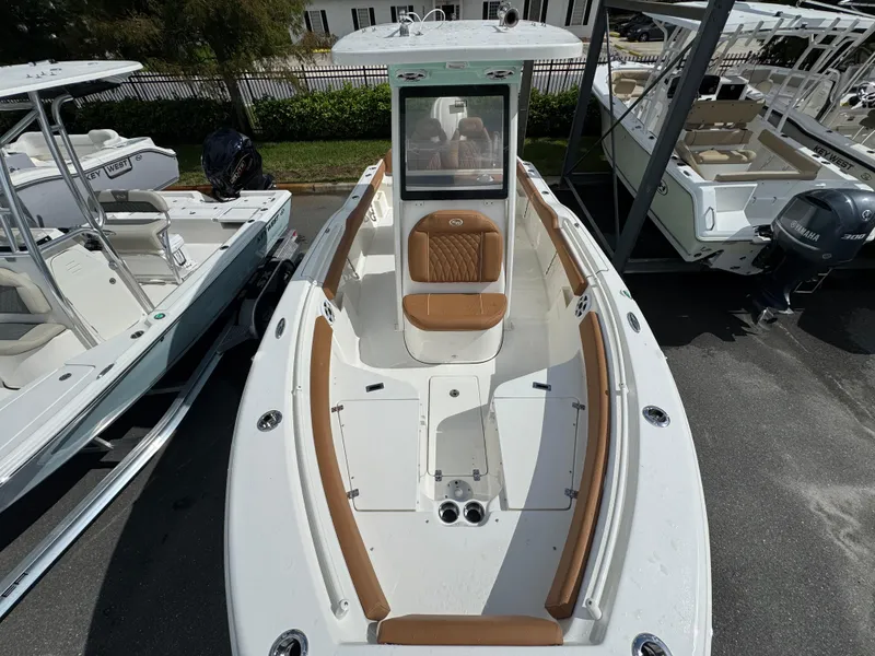 Slide: The Image of 2026 Key West 239 FSR boat with tan seating and white deck, docked outdoors. - 23