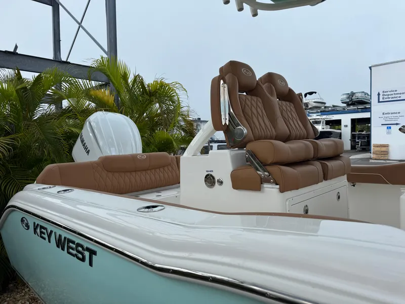 Slide: The Image of 2026 Key West 239 FSR boat with brown seating and Yamaha engine, docked near palm trees. - 8
