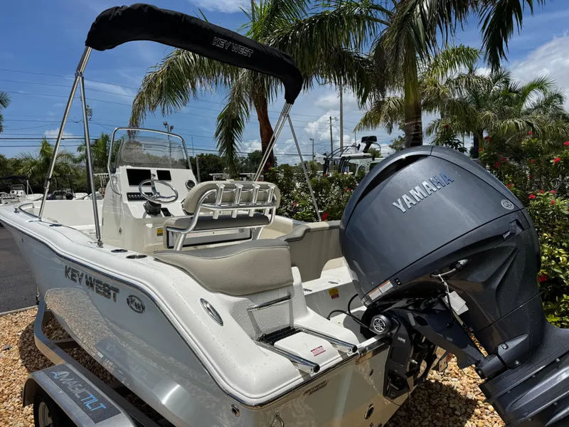 Slide: The Image of 2025 Key West 203 FS boat with Yamaha engine, parked near palm trees. - 11
