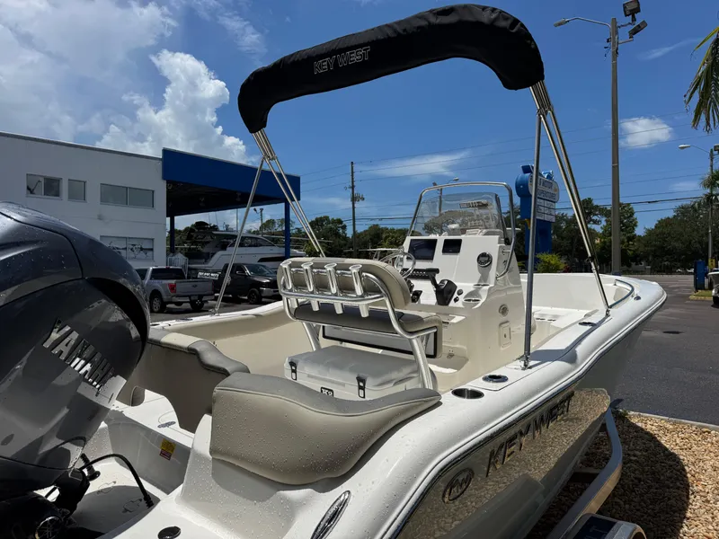 Slide: The Image of 2025 Key West 203 FS boat with Yamaha engine, parked outdoors under a clear sky. - 8