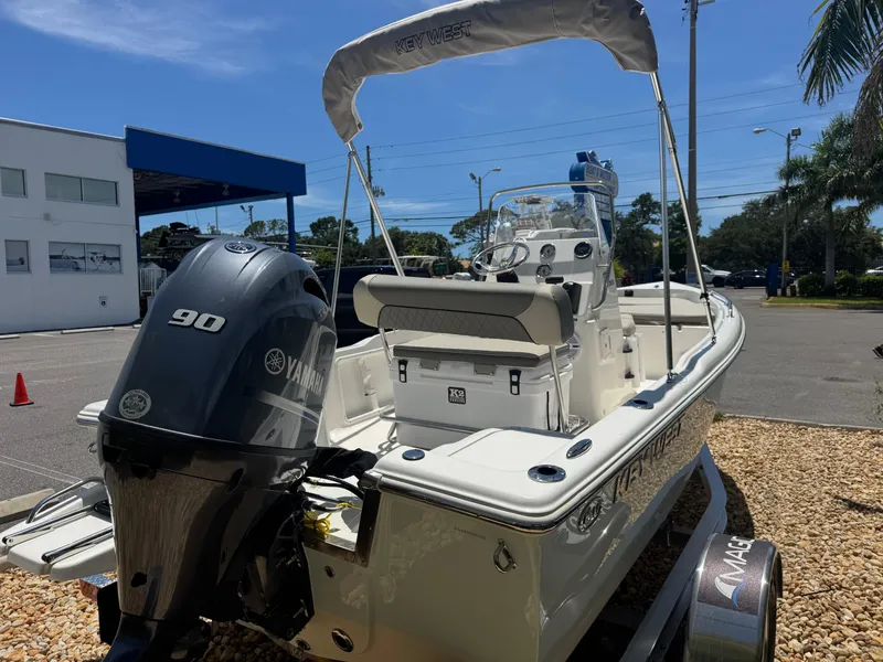 Slide: The Image of 2025 Key West 1720 Center Console boat with Yamaha 90 engine, parked outdoors. - 15