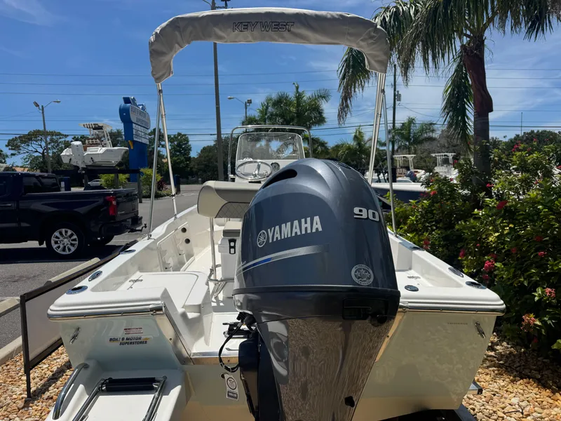 Slide: The Image of 2025 Key West 1720 Center Console boat with Yamaha 90 engine, parked outdoors. - 16