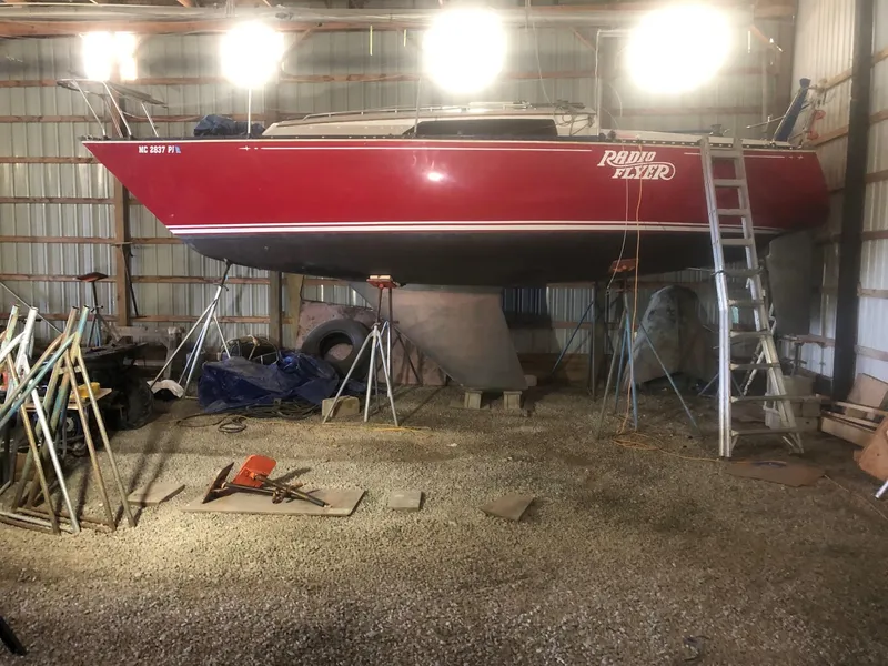 Slide: The Image of Red 1979 C&C 29 sailboat named "Radio Flyer" in a storage shed. - 11