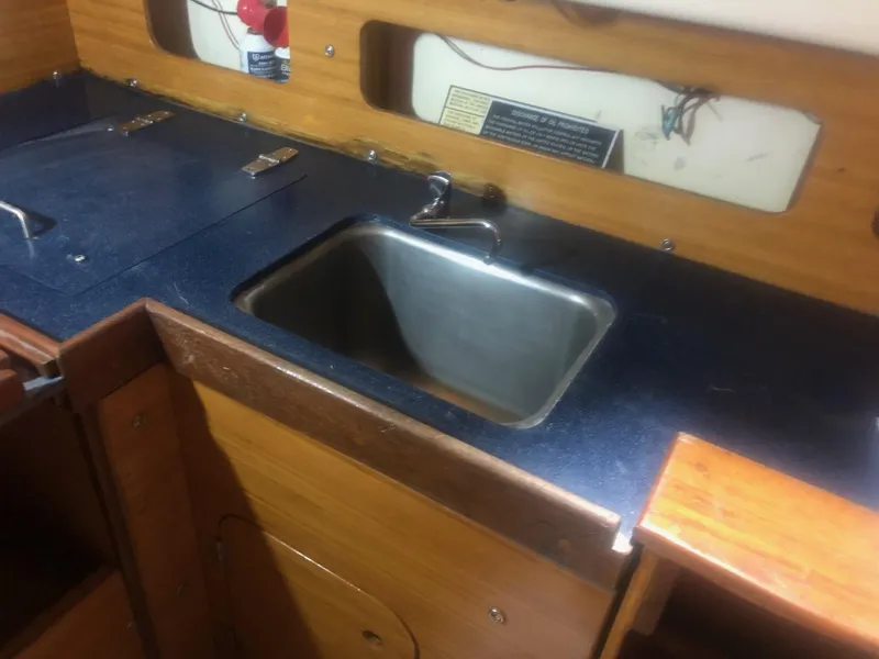 Slide: The Image of 1979 C&C 29 sailboat galley with sink and wooden cabinetry. - 7