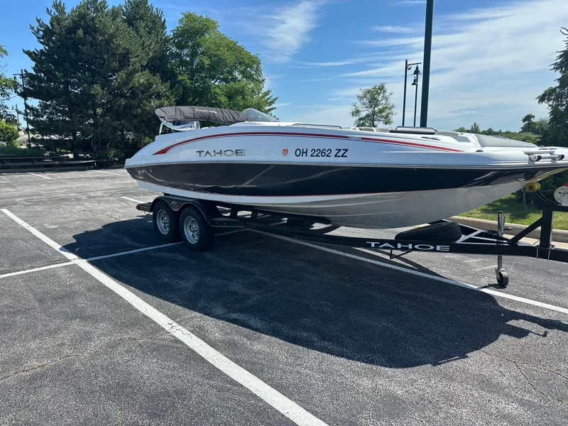 Slide: The Image of 2016 Tahoe 2150 boat on trailer in parking lot, surrounded by trees. - 3