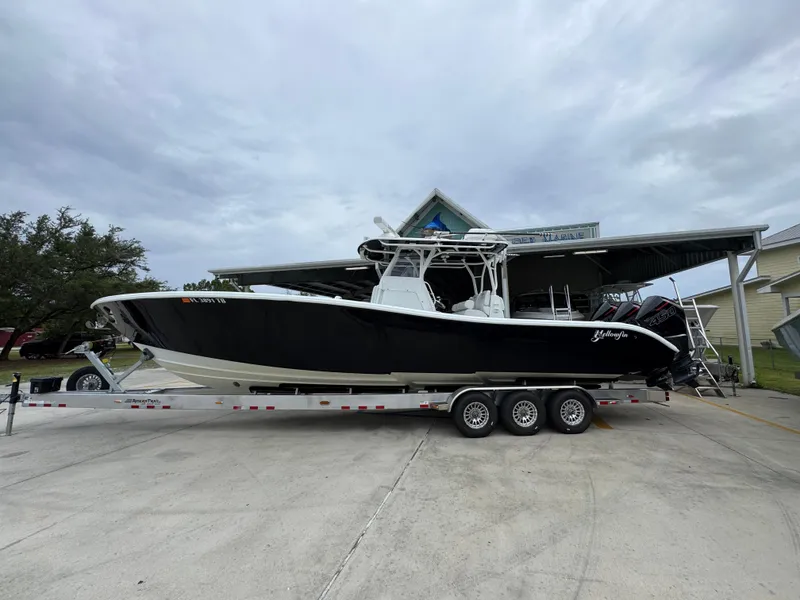 Slide: The Image of 2021 Yellowfin 36 Offshore boat on trailer, parked outdoors under cloudy sky. - 1