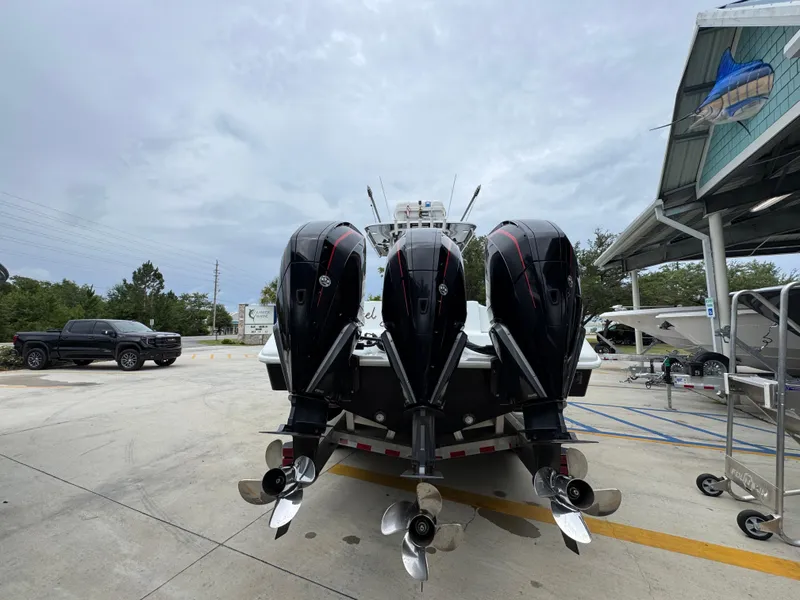 Slide: The Image of 2021 Yellowfin 36 Offshore boat with triple outboard engines in a marina setting. - 13