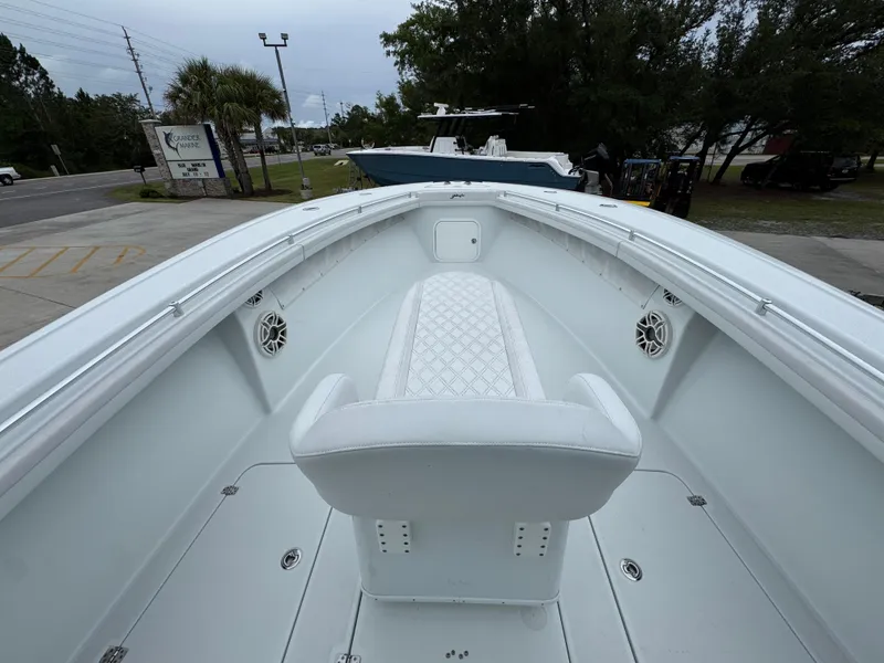 Slide: The Image of 2021 Yellowfin 36 Offshore boat interior with white seating and speakers, docked outdoors. - 17
