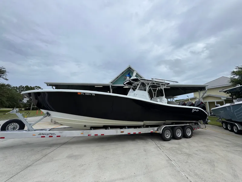 Slide: The Image of 2021 Yellowfin 36 Offshore boat on trailer, parked outdoors under cloudy sky. - 2