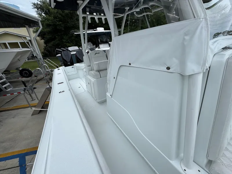 Slide: The Image of 2021 Yellowfin 36 Offshore boat interior with seating and storage, docked outdoors. - 25