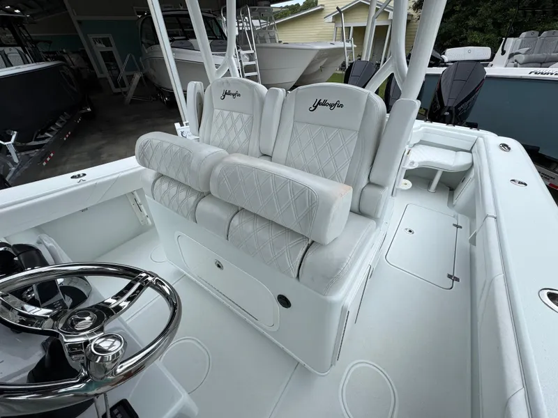 Slide: The Image of 2021 Yellowfin 36 Offshore boat interior with white seating and steering wheel. - 26