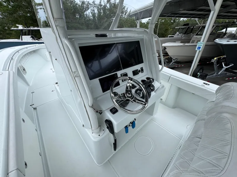 Slide: The Image of 2021 Yellowfin 36 Offshore boat cockpit with steering wheel and dual screens. - 28