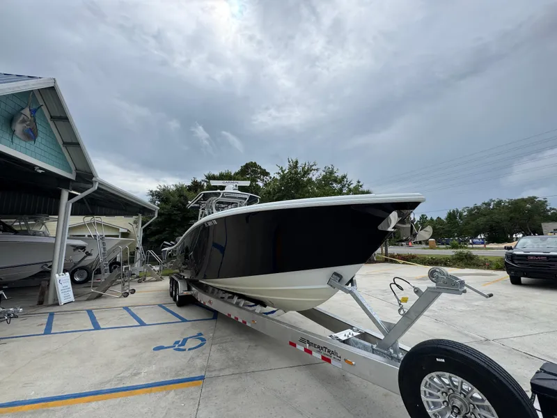 Slide: The Image of 2021 Yellowfin 36 Offshore boat on trailer at dealership, under cloudy sky. - 6