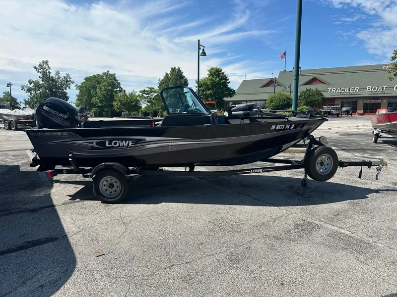 Slide: The Image of 2016 Lowe FM 165 Pro WT fishing boat on trailer, parked outdoors. - 0
