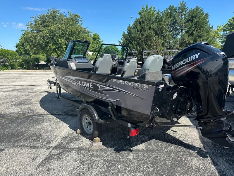 Slide: The Image of 2016 Lowe FM 165 Pro WT fishing boat with Mercury outboard motor in a parking lot. - 6