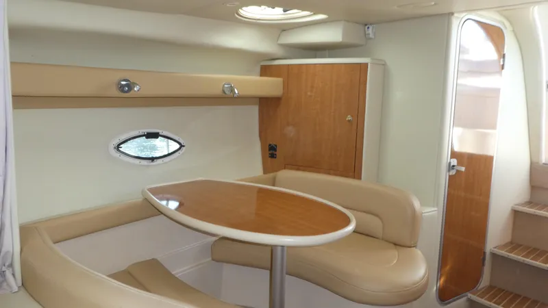 Slide: The Image of Interior of 2002 Maxum 3100 SCR yacht with beige seating and wooden table. - 12
