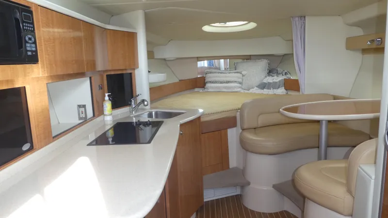Slide: The Image of 2002 Maxum 3100 SCR yacht interior with kitchenette, seating area, and cozy sleeping quarters. - 20