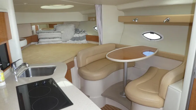 Slide: The Image of 2002 Maxum 3100 SCR cabin interior with kitchenette, dining area, and cozy sleeping space. - 24