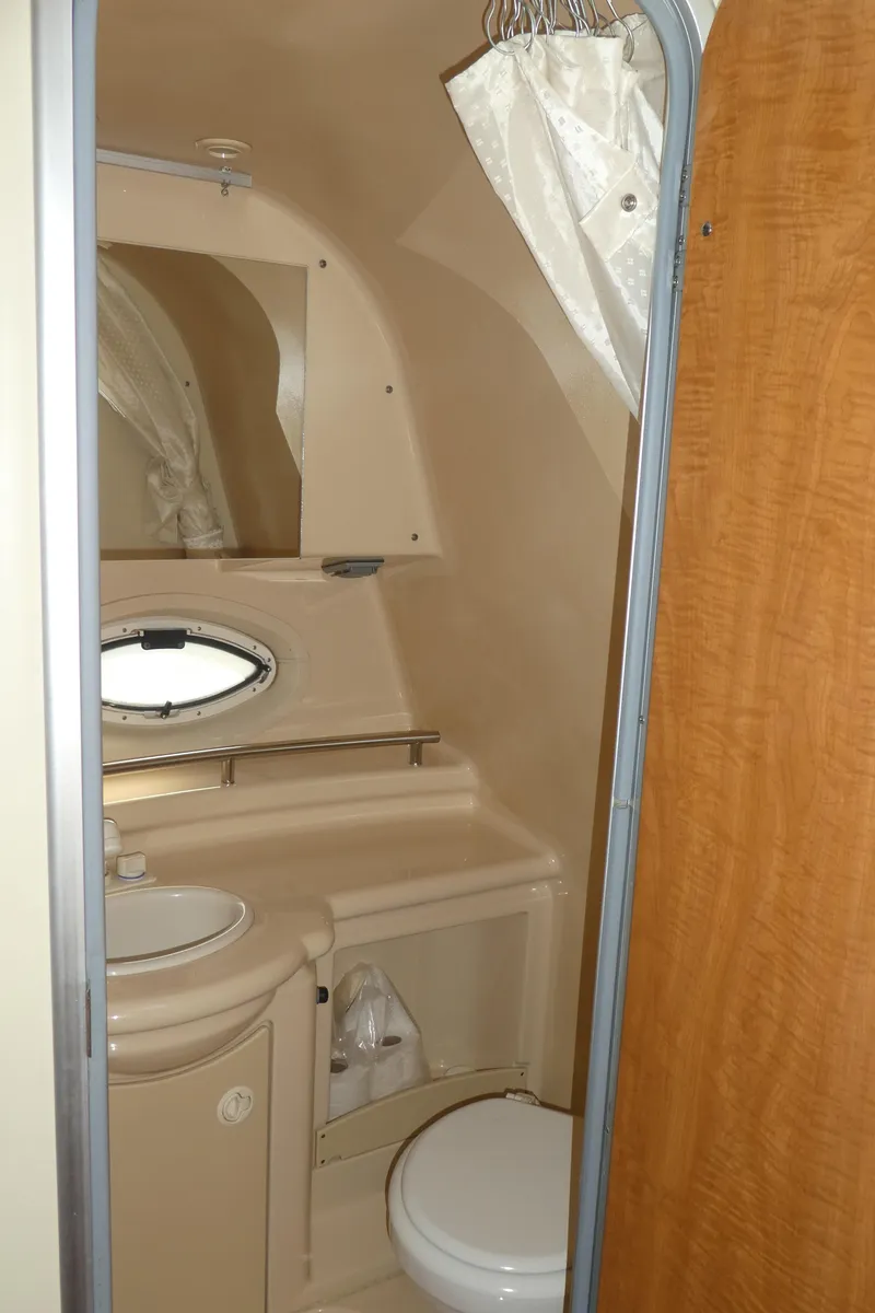 Slide: The Image of 2002 Maxum 3100 SCR boat bathroom with sink, toilet, and porthole window. - 26