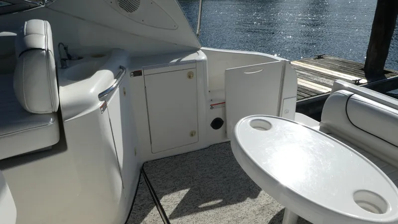 Slide: The Image of 2002 Maxum 3100 SCR boat interior with seating and table by the water. - 5
