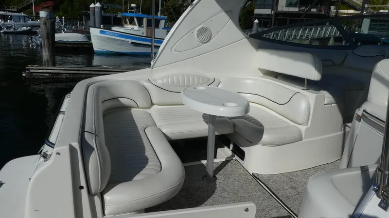 Slide: The Image of 2002 Maxum 3100 SCR boat interior with white seating and table, docked at marina. - 6