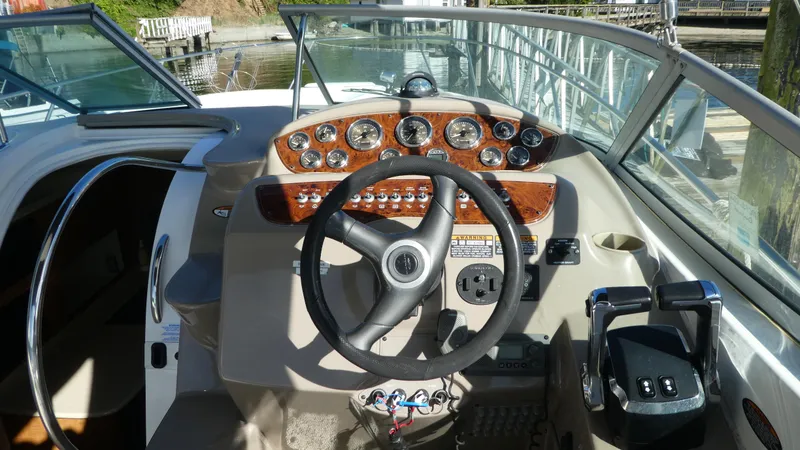 Slide: The Image of 2002 Maxum 3100 SCR boat helm with steering wheel and control panel. - 9