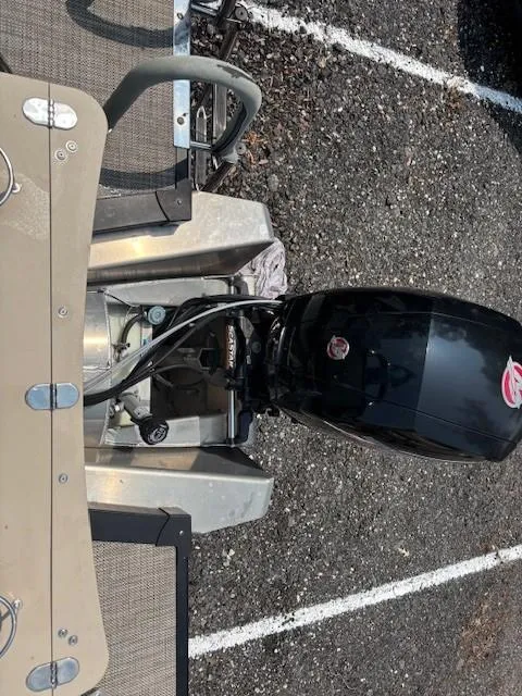 Slide: The Image of 2021 Avalon Catalina Quad Lounger boat with outboard motor, parked on gravel. - 17