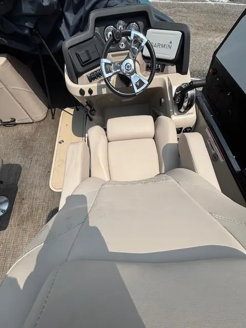 Slide: The Image of 2021 Avalon Catalina Quad Lounger boat interior with steering wheel and beige seating. - 21