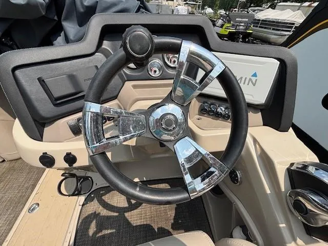 Slide: The Image of Steering wheel of 2021 Avalon Catalina Quad Lounger boat, featuring modern controls and dashboard. - 22