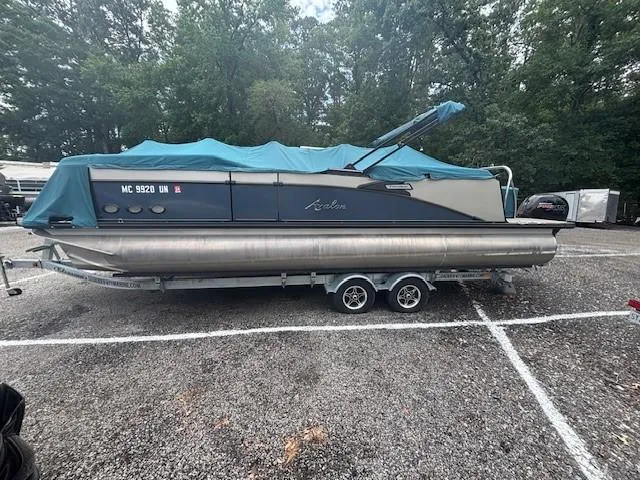 Slide: The Image of 2021 Avalon Catalina Quad Lounger pontoon boat on trailer, covered, in parking lot. - 3