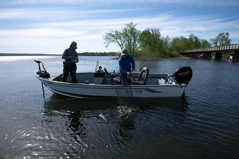 Slide: The Image of Manufacturer Provided Image: Two people fishing on a 2025 Lund 1600 Fury SS boat in a scenic lake. - 17