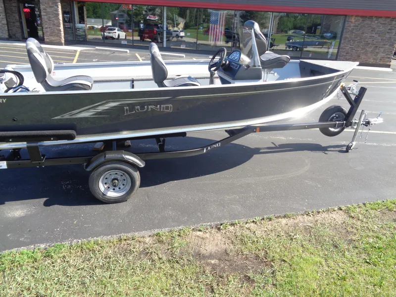 Slide: The Image of 2025 Lund 1600 Fury SS boat on trailer, parked outside a store. - 6