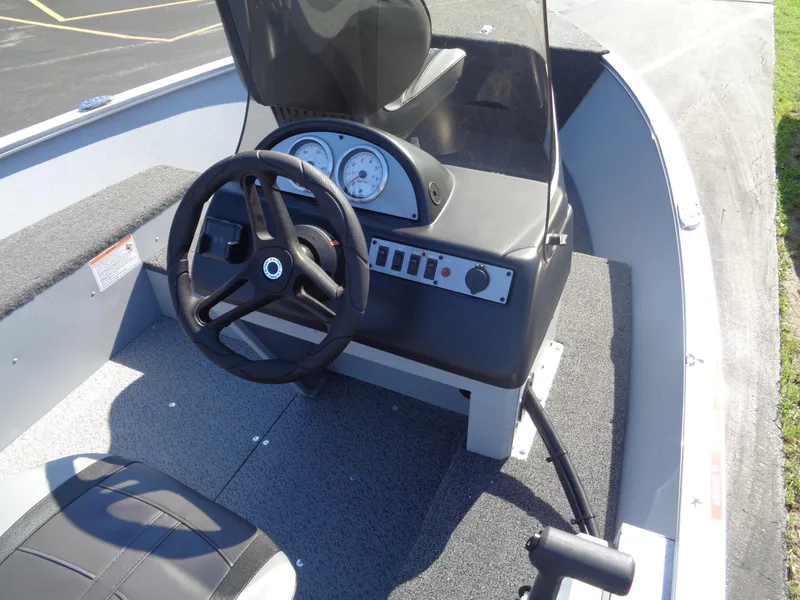 Slide: The Image of 2025 Lund 1600 Fury SS boat console with steering wheel and gauges. - 8