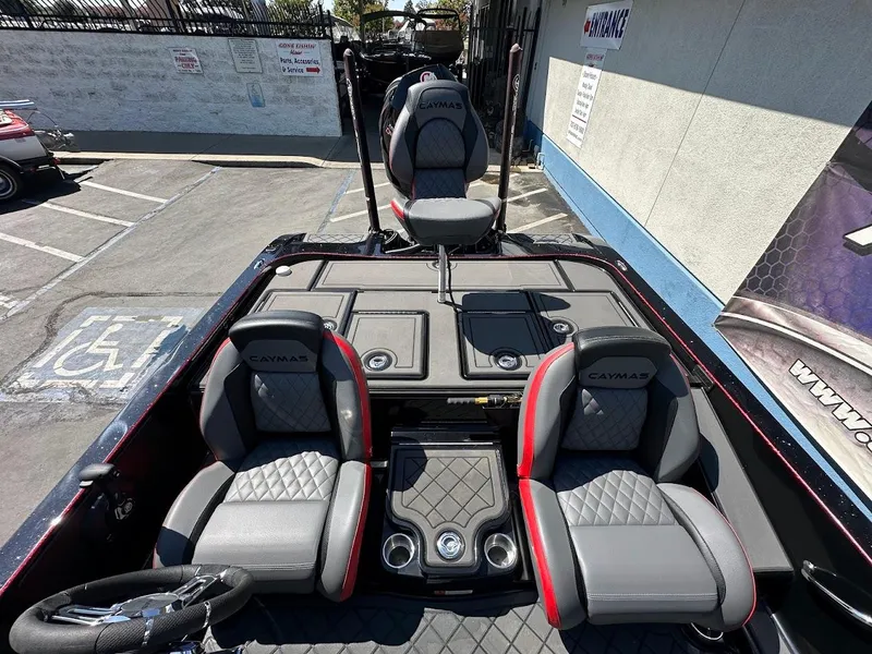 Slide: The Image of 2024 Caymas XS 20 Pro boat interior with gray and red seating, steering wheel, and storage compartments. - 16