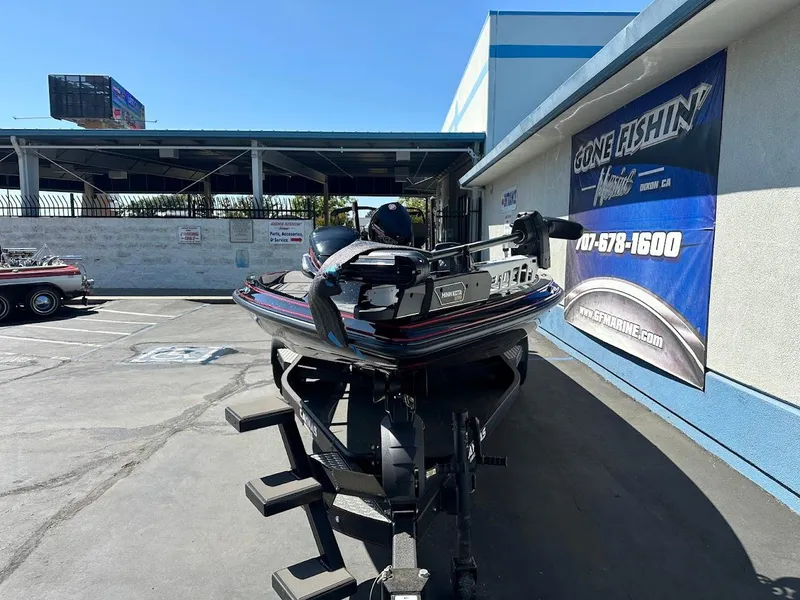 Slide: The Image of 2024 Caymas XS 20 Pro boat parked at dealership with promotional banner. - 2
