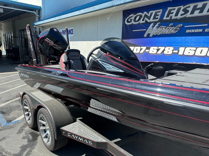 Slide: The Image of 2024 Caymas XS 20 Pro boat at dealership, sleek black design with red accents. - 6