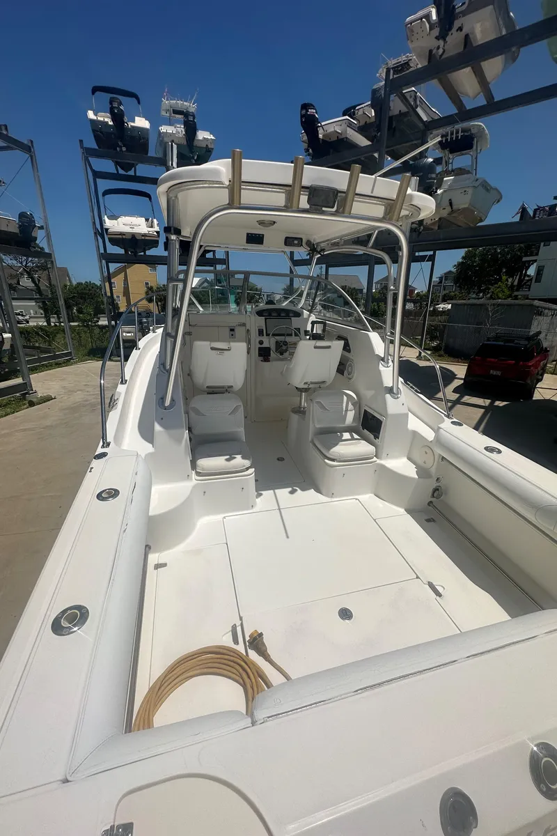 Slide: The Image of 2002 Boston Whaler 255 Conquest boat with spacious deck and seating, docked outdoors. - 5