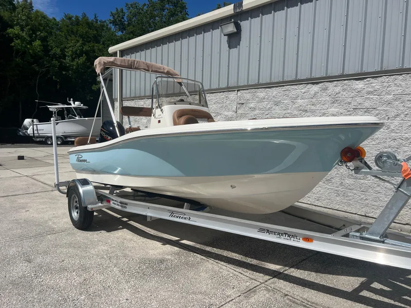 The Image of 2026 Pioneer 180 Islander boat on trailer, parked outdoors near a building. - 1