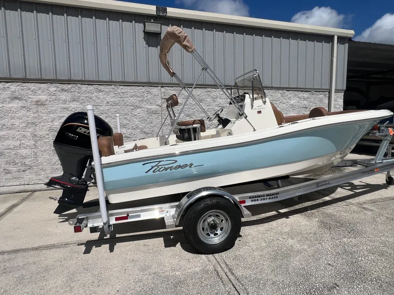 Slide: The Image of 2026 Pioneer 180 Islander boat on trailer, light blue hull, parked outdoors. - 4