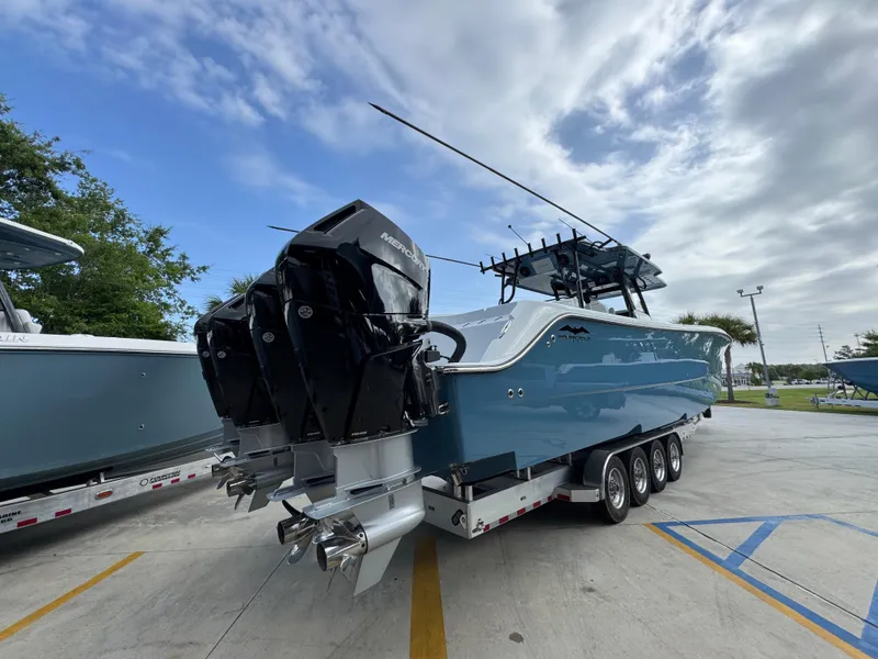 Slide: The Image of 2026 Invincible 46 Catamaran with powerful outboard engines on a trailer, under a cloudy sky. - 12