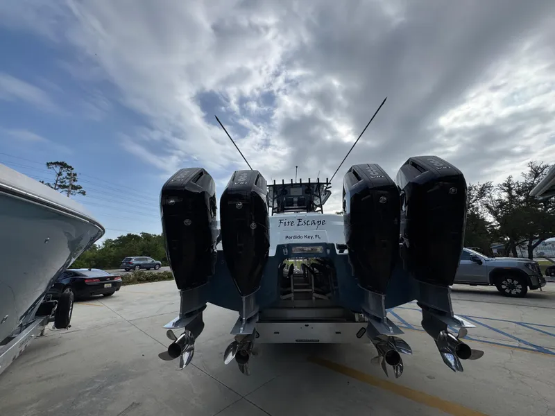 Slide: The Image of 2026 Invincible 46 Catamaran with four powerful outboard engines, parked outdoors under cloudy skies. - 14