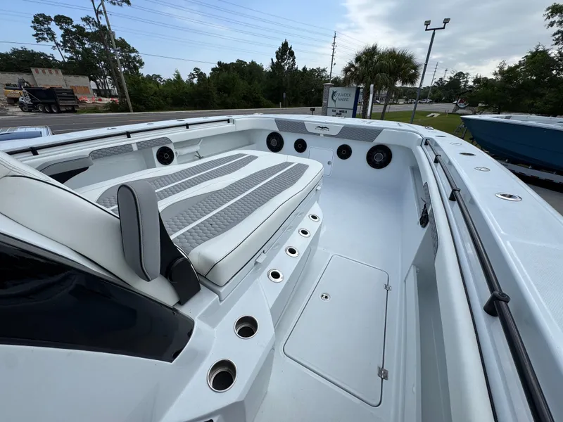 Slide: The Image of 2026 Invincible 46 Catamaran interior with seating and speakers, docked outdoors. - 16