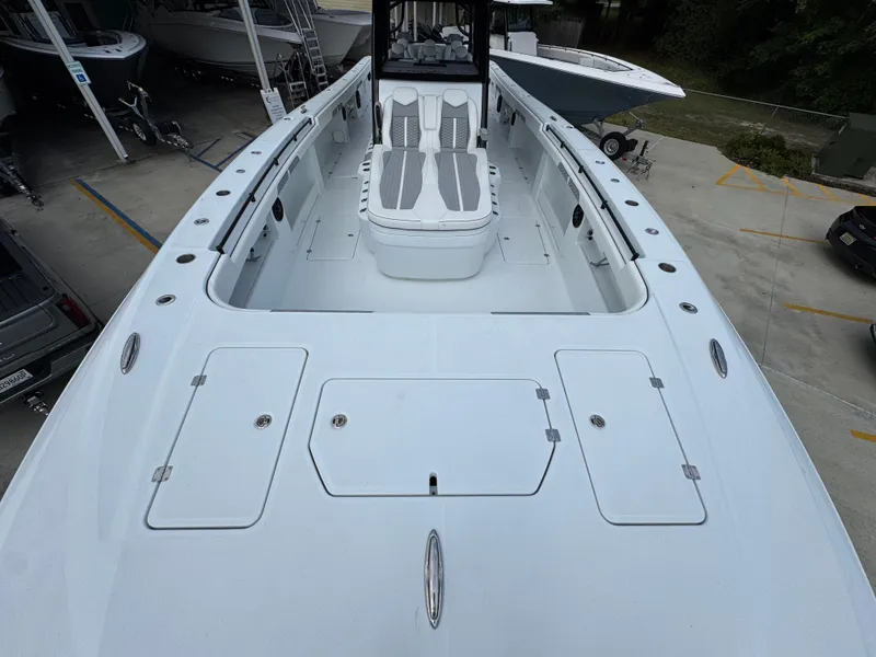 Slide: The Image of 2026 Invincible 46 Catamaran with spacious deck and seating, docked in a marina. - 19