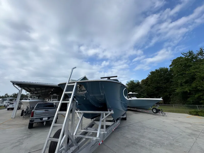 Slide: The Image of 2026 Invincible 46 Catamaran on trailer under cloudy sky, parked near trees. - 5